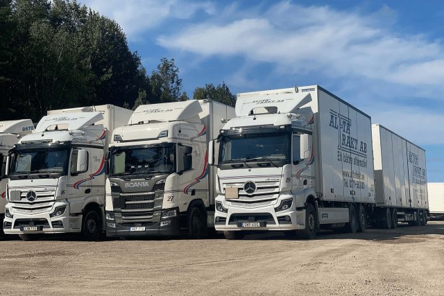 Alfta Frakt. Fyra lastbilar med släp parkerade bredvid varandra.